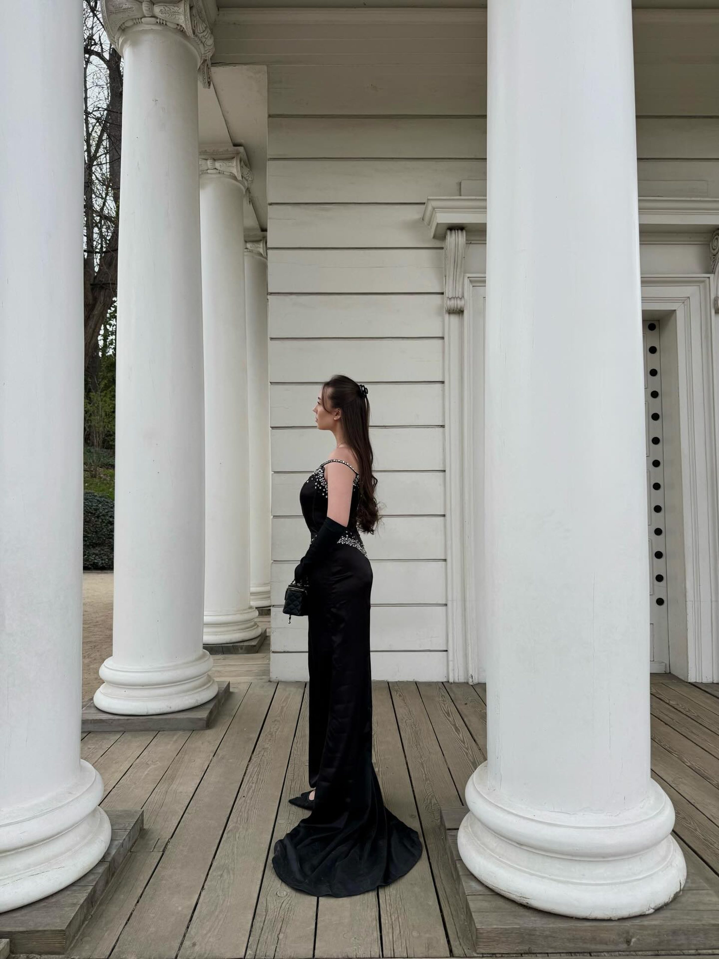 Architectural silhouette between white columns, black gown