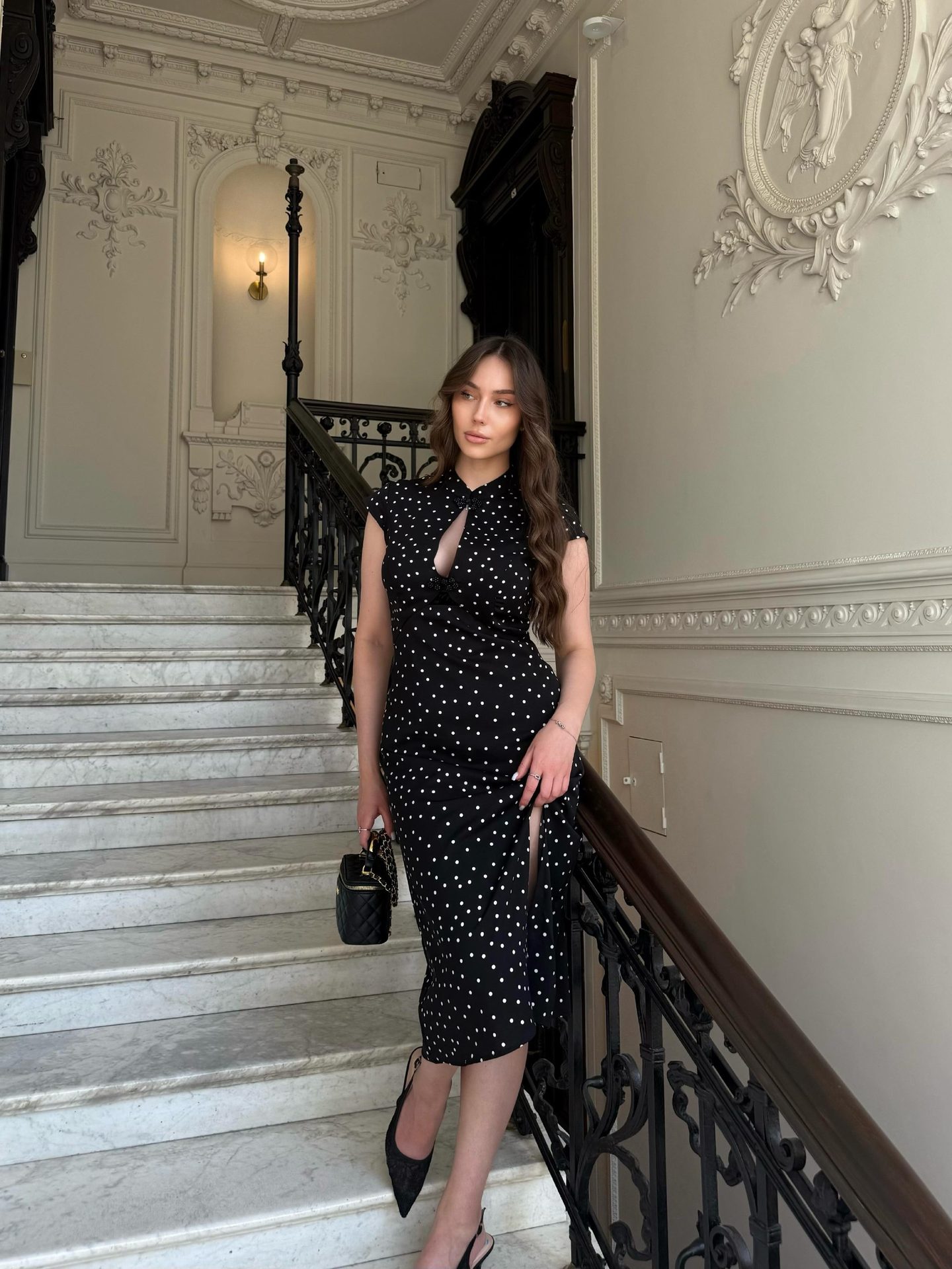 Daria Dombrovskaya — editorial portrait, black polka-dot dress on a marble staircase
